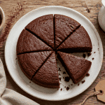 Gateau cacao moelleux découpé sur table rustique