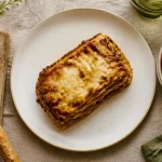 Accompagnement pour lasagne : part de lasagne, salade roquette, gressins et focaccia au romarin