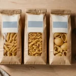 Pâtes italiennes marques artisanales vs industrie sur table bois, mortier et pecorino